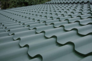 Acoperiș metalic verde cu un design ondulat, privit dintr-un unghi scăzut.